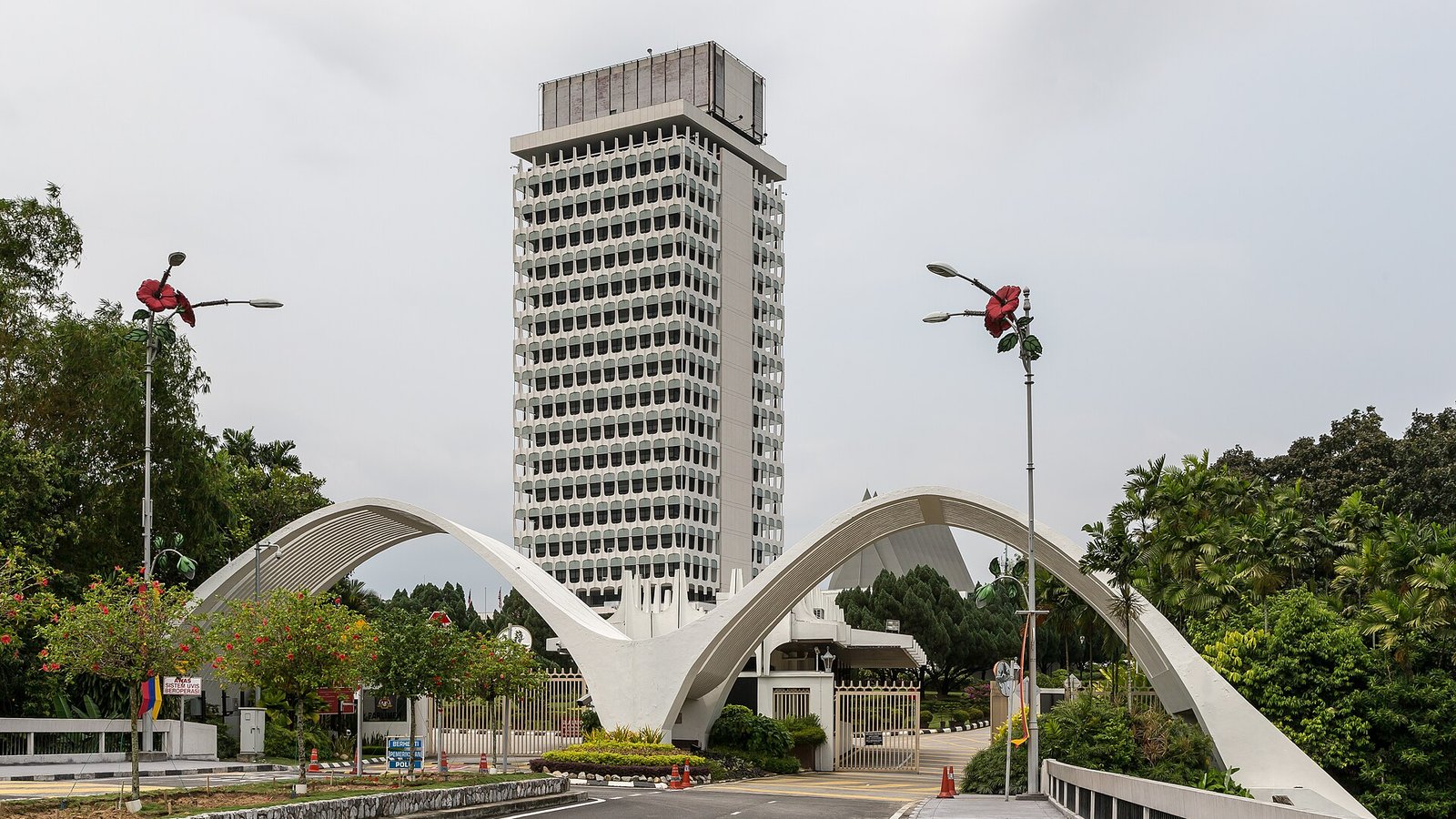 吉隆坡国会大厦与入口白色拱形大门，天空阴沉