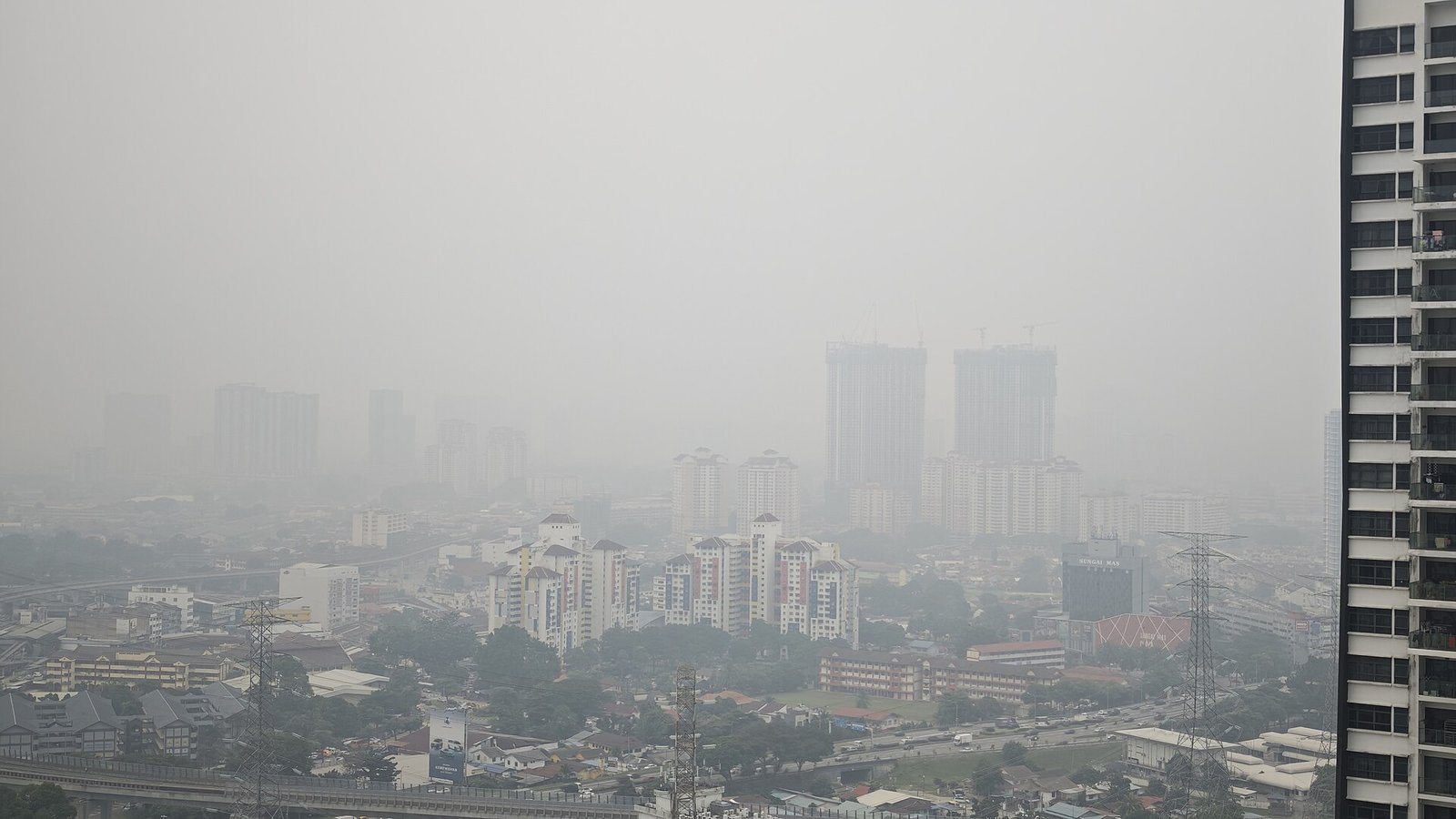 烟霾笼罩下的吉隆坡城市景观，远处高楼轮廓模糊