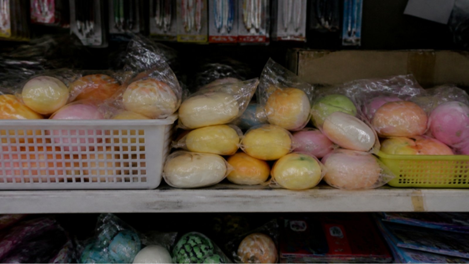 玩具店货架上摆放着装在透明袋和篮子里的软胶squishy玩具