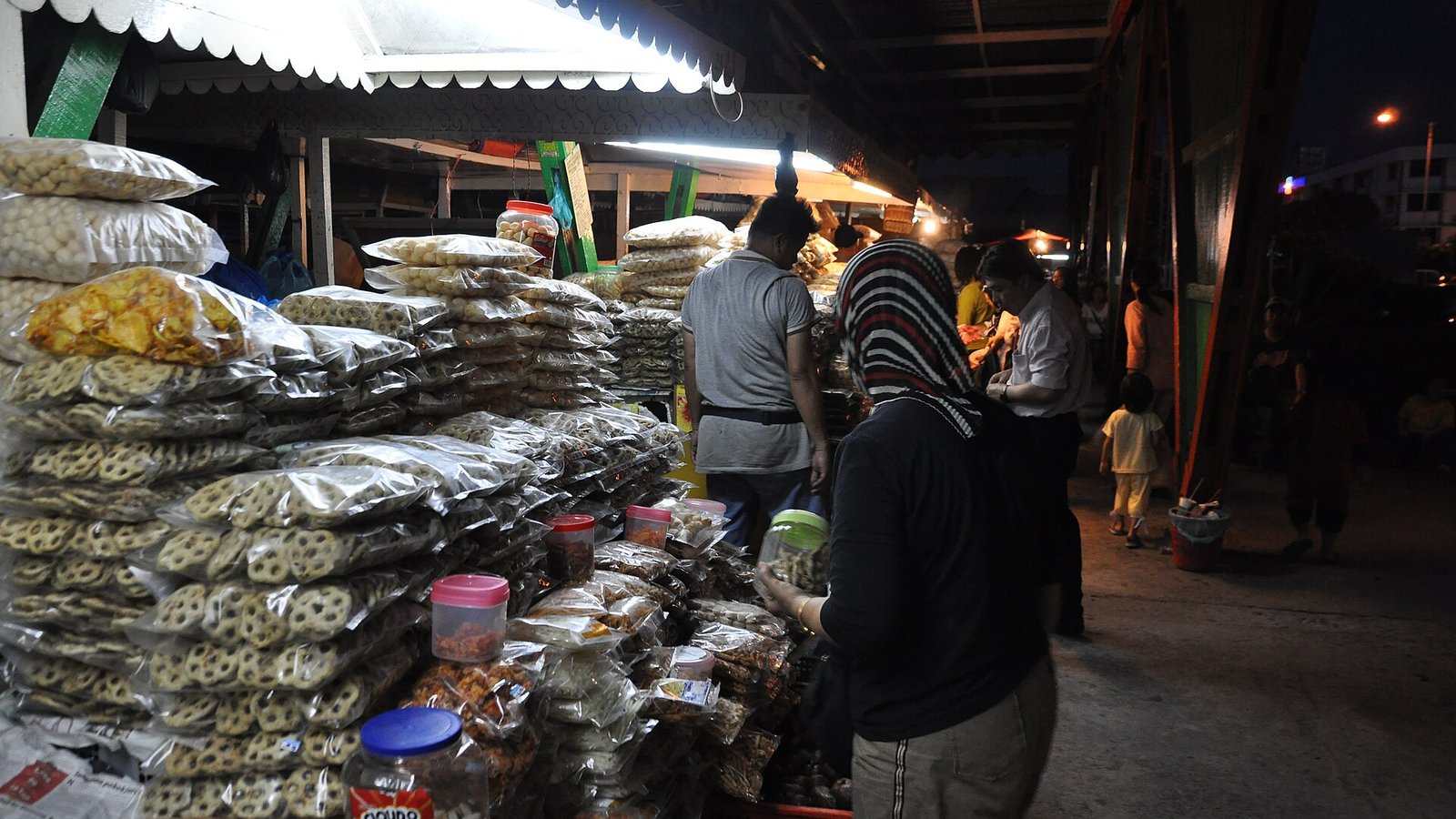马来西亚哥打京那巴鲁市场摊位上堆放的袋装零食与饼干