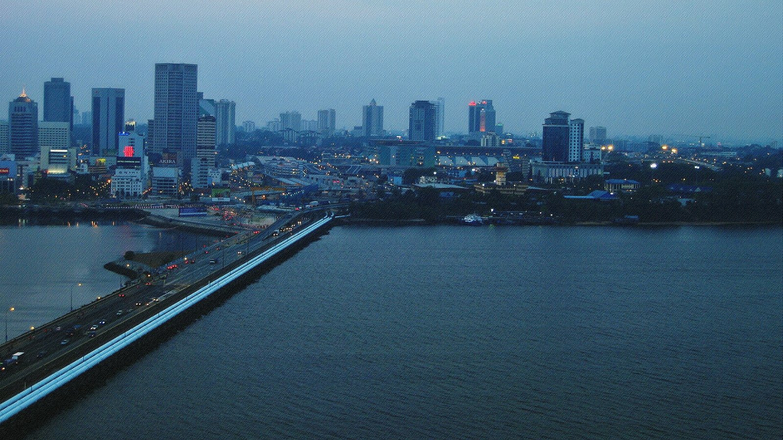 黄昏时分的新柔长堤与新山市区天际线，长堤上车流亮灯